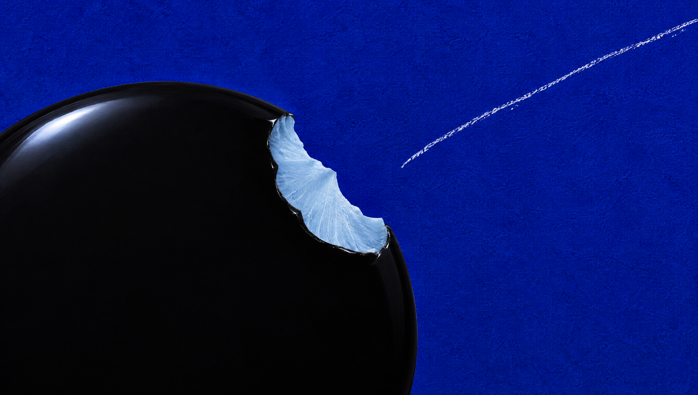 A glossy black sphere with an icy blue core against a rich blue background.